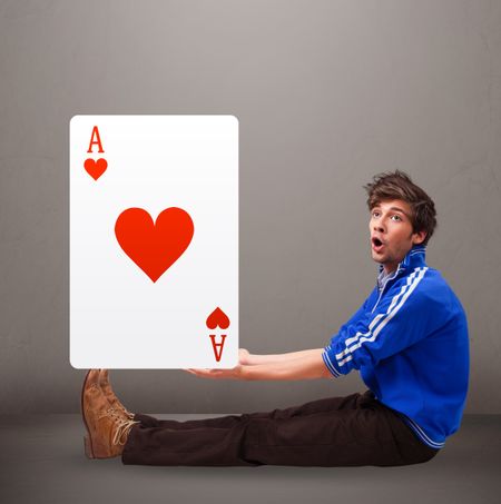 Attractive young man holding a red heart ace
