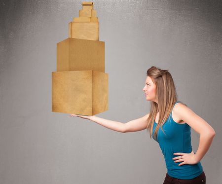 Attractive young lady holding a set of brown cardboard boxes