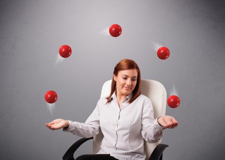 pretty young girl sitting and juggling with red balls