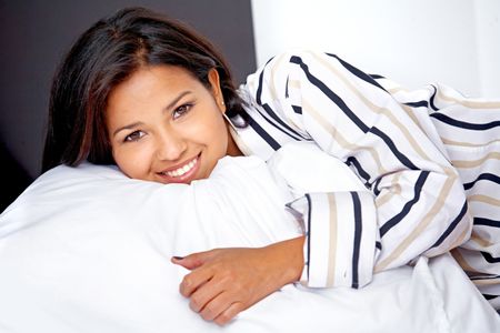 beautiful woman portrait smiling and lying on the bed