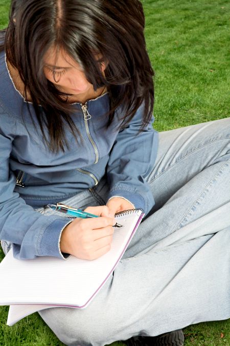 beautiful student working outdoors in a park