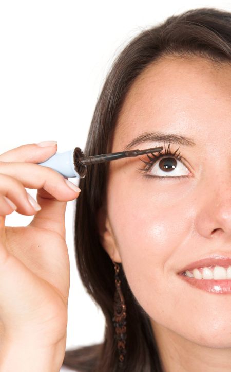 beautiful girl making up her eyes with mascara