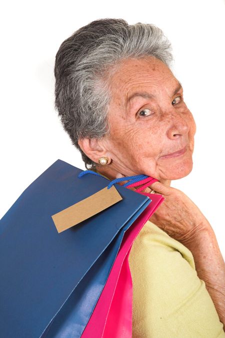 beautiful elderly woman with shopping bags over white