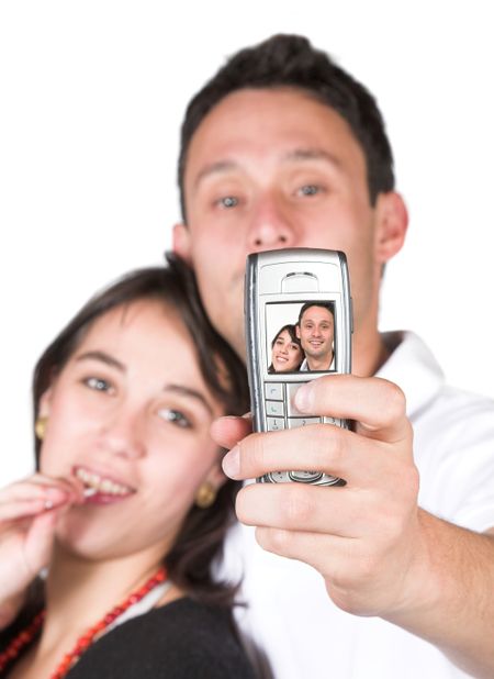 couple taking a self portrait over white - focus on mobile phone