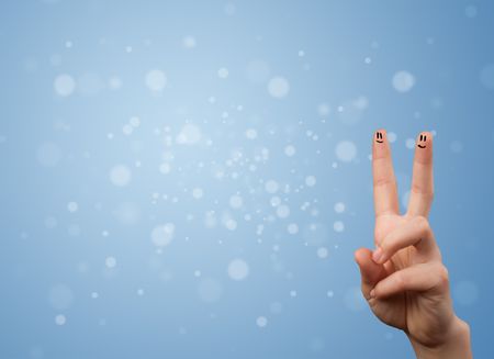 Happy finger smileys faces on hand with empty blue bokeh background