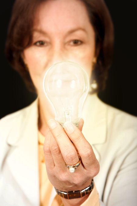 business woman holding a light bulb while it is on