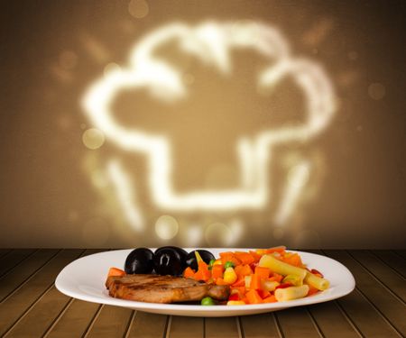 Delicious food plate with chef cook hat on wood deck