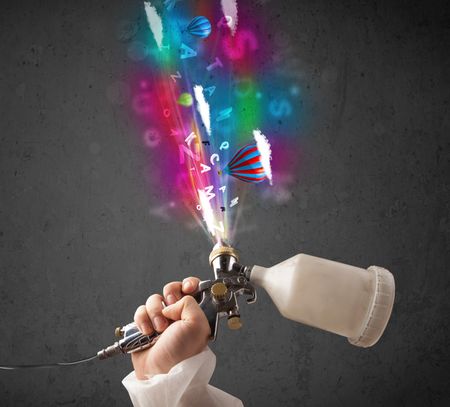 Worker with airbrush and colorful abstract clouds and balloons concept