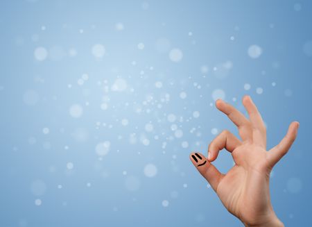 Happy finger smileys faces on hand with empty blue bokeh background