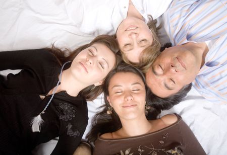 family without worries - sleeping over a white blanket - soft focus