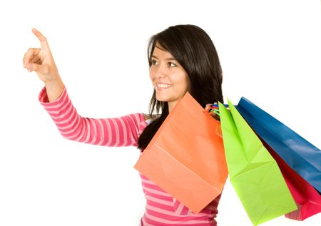 beautiful teenager with shopping bags over white pointing at the screen