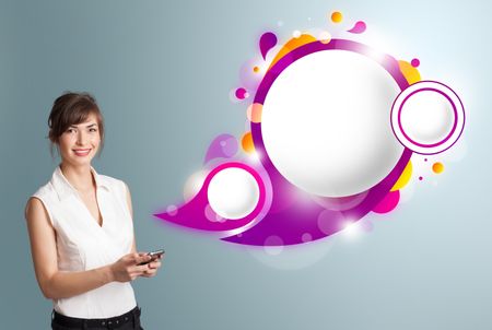 Pretty young woman holding a phone and presenting abstract speech bubble copy space
