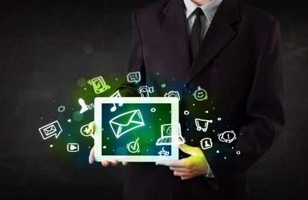 Person holding a white tablet with media icons and symbols