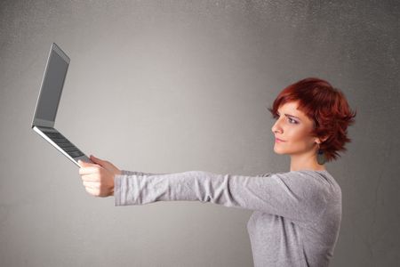 Pretty young woman holding modern laptot