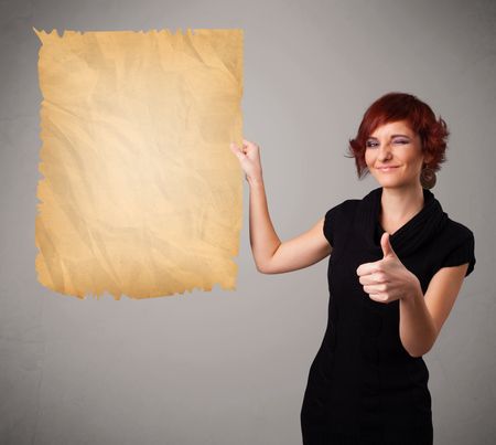 Beautiful young girl presenting old paper copy space