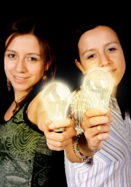 beautiful twin girls holding light bulbs
