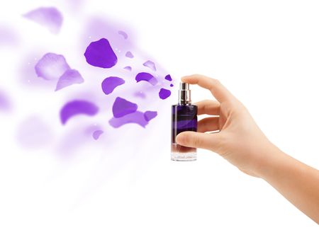 close up of woman hands spraying rose petals from beautiful perfume bottle