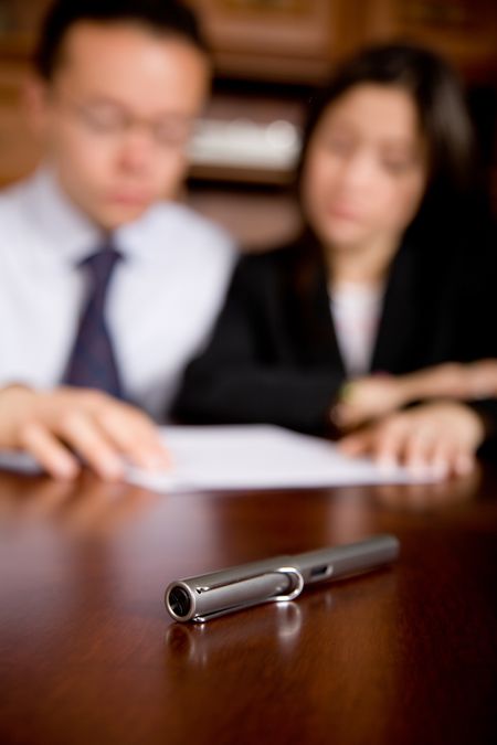 business people in an office about to sign a contract