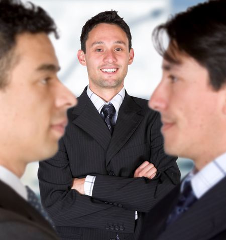 business man facing the camera with his parters either side with blurry faces