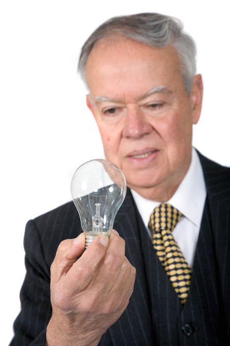 business senior with a lightbulb thinking of ideas for his business over a white background