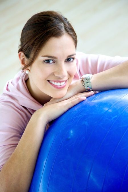 gym woman doing pilates exercises on a blue ball