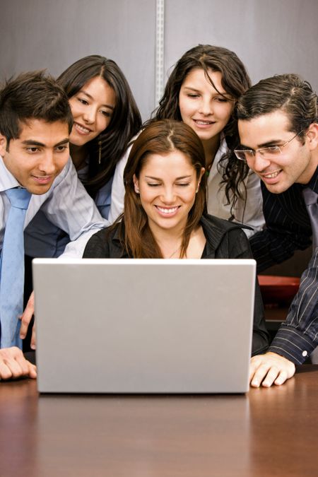 business team on a laptop in an office smiling