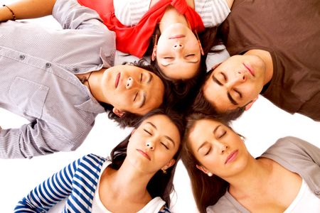 group of friends smiling with their heads together on the floor - isolated