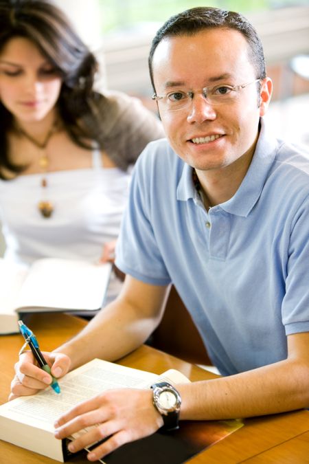 male university student taking notes on a notebook