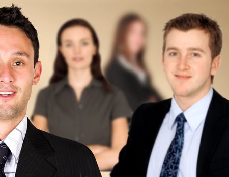 friendly business man smiling with his colleagues blurred in the background