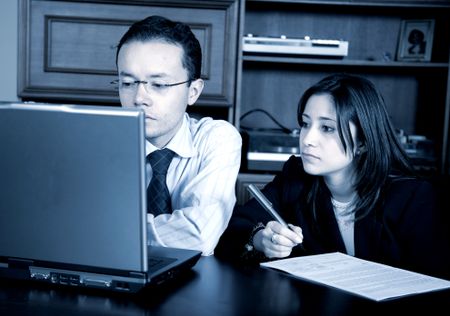 business partners on a laptop in an office taking notes - blue tint