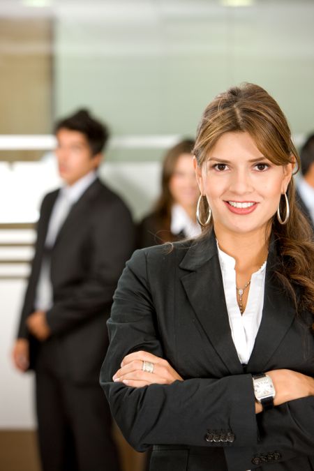business woman in an office environment with people working behind her