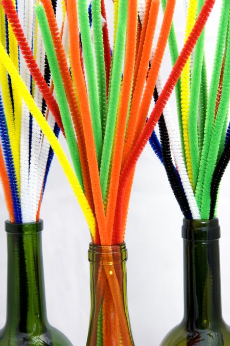 Bouquets of pipe cleaners in three wine bottles