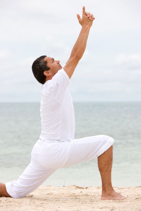beach man doing yoga exercises outdoors - senior
