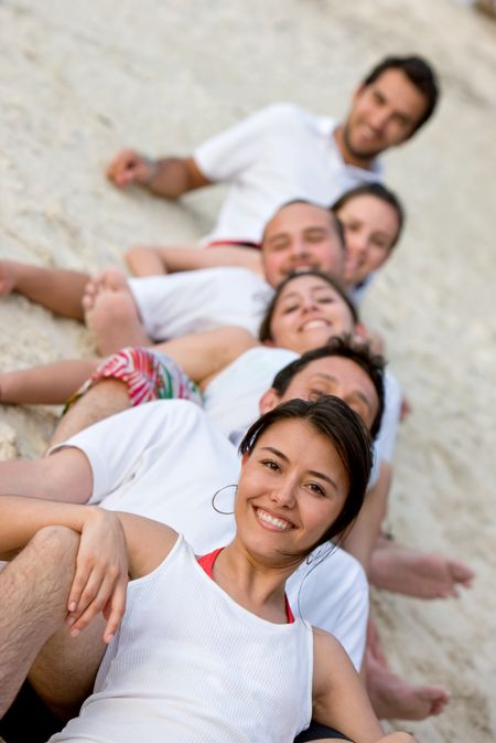 Happy group of friends smiling at the beach