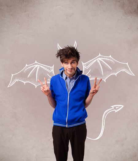 Young nasty man with devil horns and wings drawing