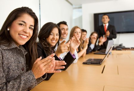 business success team in an office clapping a presentation
