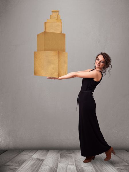 Attractive young lady holding a set of brown cardboard boxes
