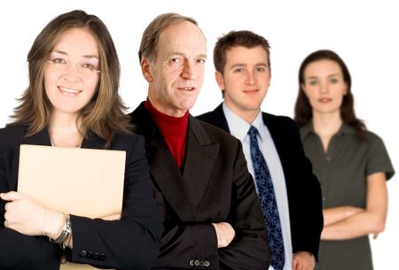 business woman facing the camera with a folder with her team behind her