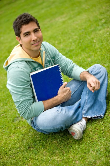 male university student in a classroom smiling outdoors