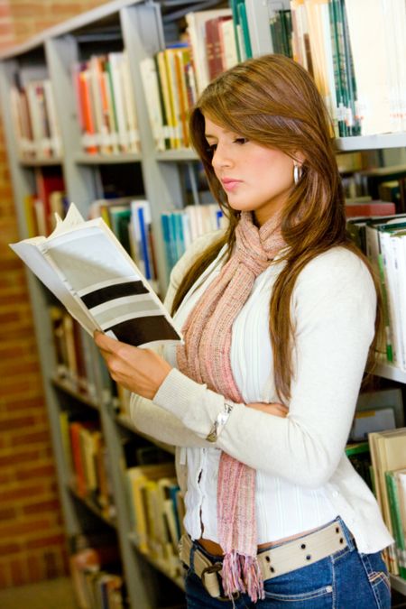 beautiful female student with a book in the library