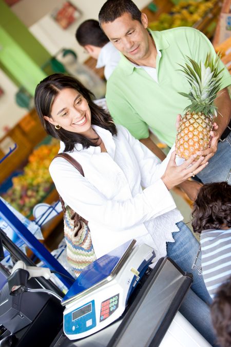 Beautiful couple at a supermarket checkout  on a shopping till in a market