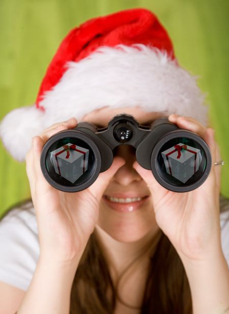 female santa searching for gifts - note the gifts on the binoculars lens reflection