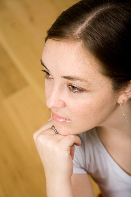 beautiful pensive woman portrait with a wooden floor in the background