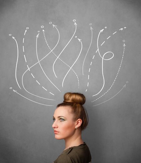 Pretty young woman thinking with arrows in different directions above her head