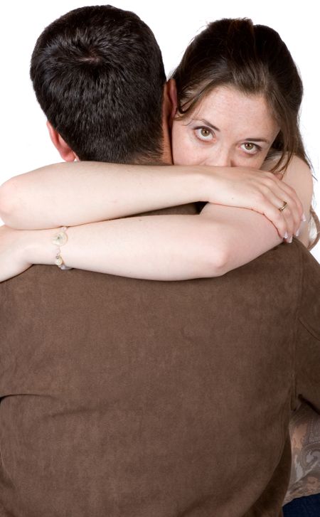 couple hugging - woman is looking intensely at the camera over his shoulder - white background