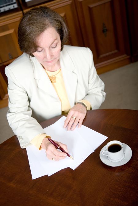 business woman writing a letter in her office
