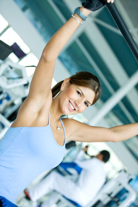 woman at the gym doing back exercises on a machine