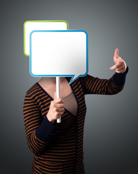 Young lady standing and holding an empty speech bubble in front of her head
