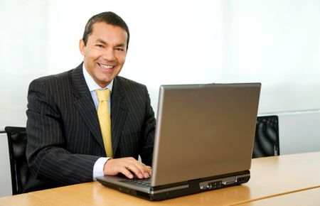 business man looking happy on a laptop in an office