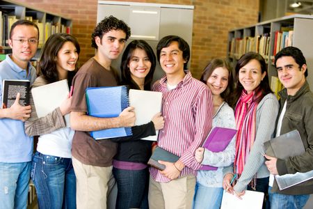 group of happy students in a library smiling